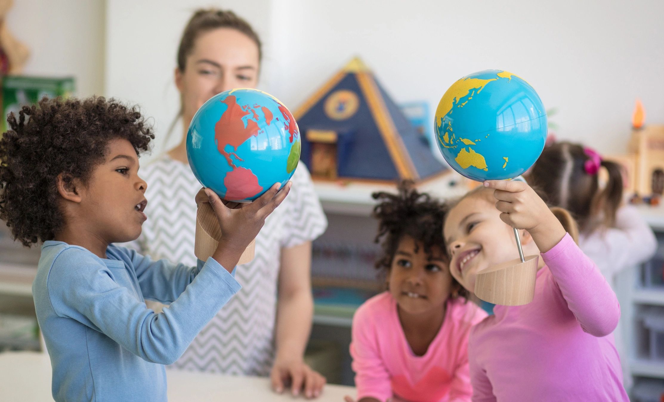 Preschool children learning with a globe