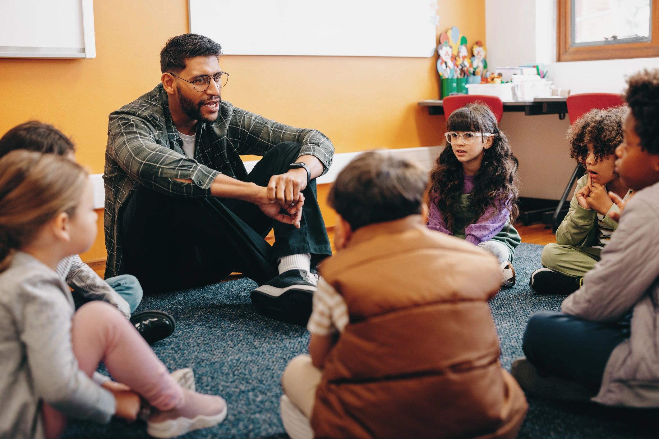 Teacher and children sitting together in a classroom circle