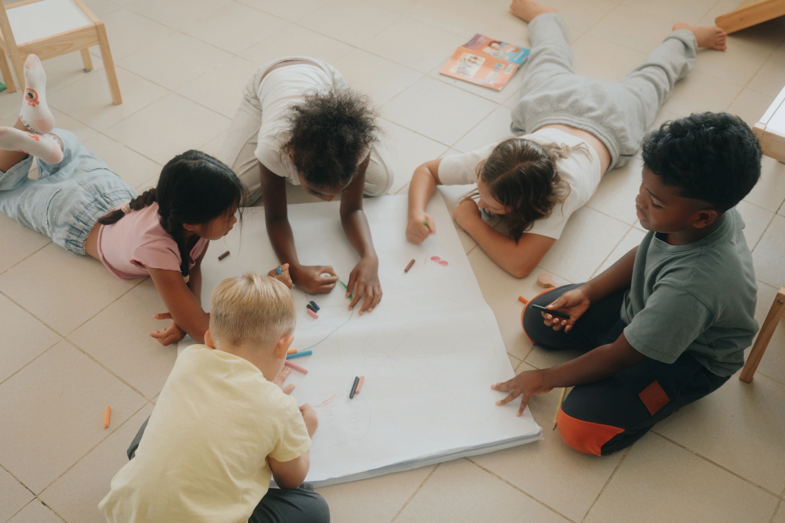 Children coloring and drawing together in a kindergarten classroom