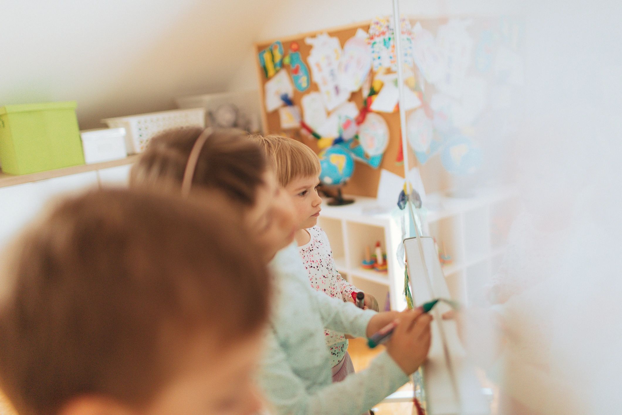 Preschool children drawing on a classroom board